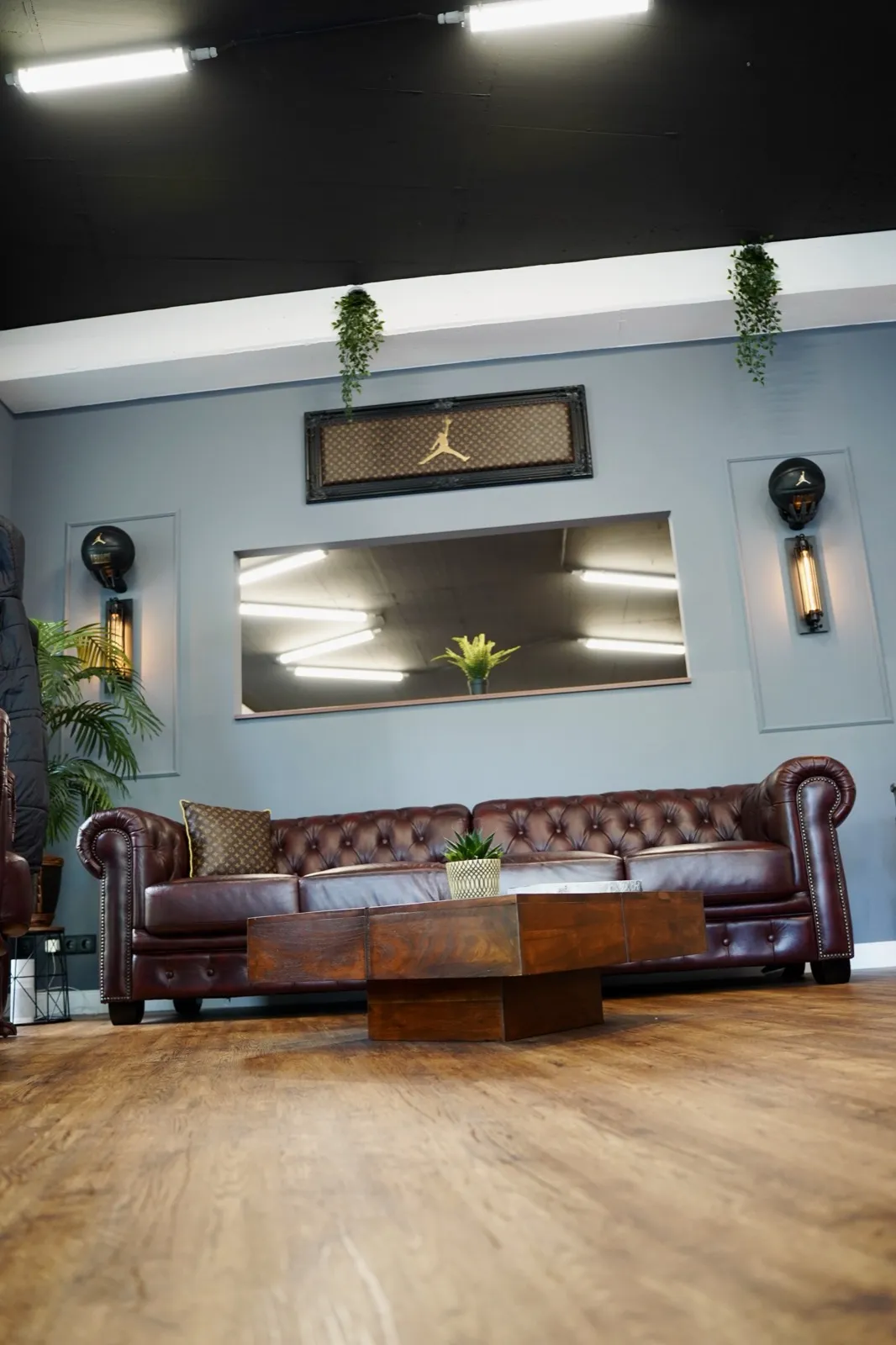 Chesterfield-Sofa, Couchtisch und Garderobe von Woodkings in der Lounge von Tattoo Highlights in Hamburg