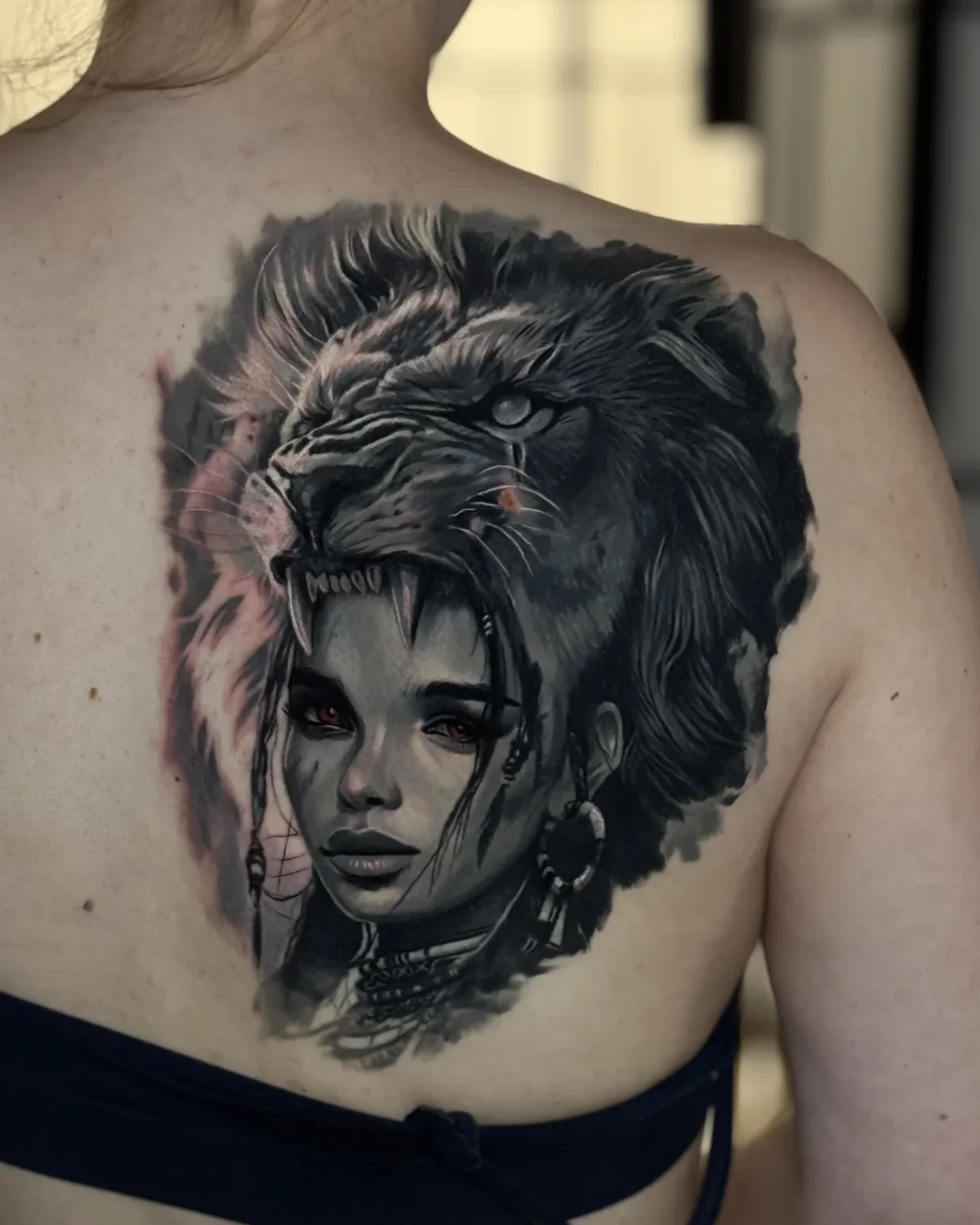 Nachher: Kriegerin-Porträt mit Löwenkopf-Kopfschmuck, deckt das Tribal am Schulterblatt ab | Cover-up bei Tattoo-Highlights Hamburg