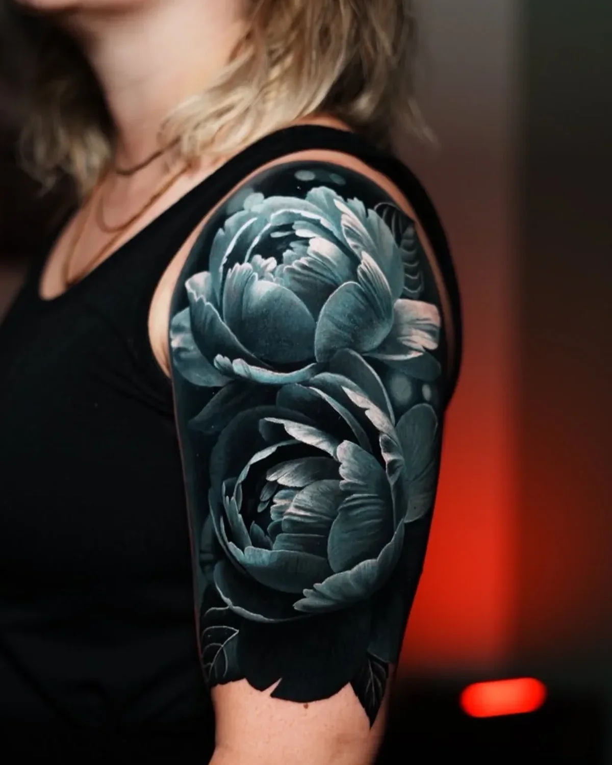 Nachher: zwei große Pfingstrosen in dunklem Realismus über dem alten Pony am Oberarm | Cover-up bei Tattoo-Highlights Hamburg