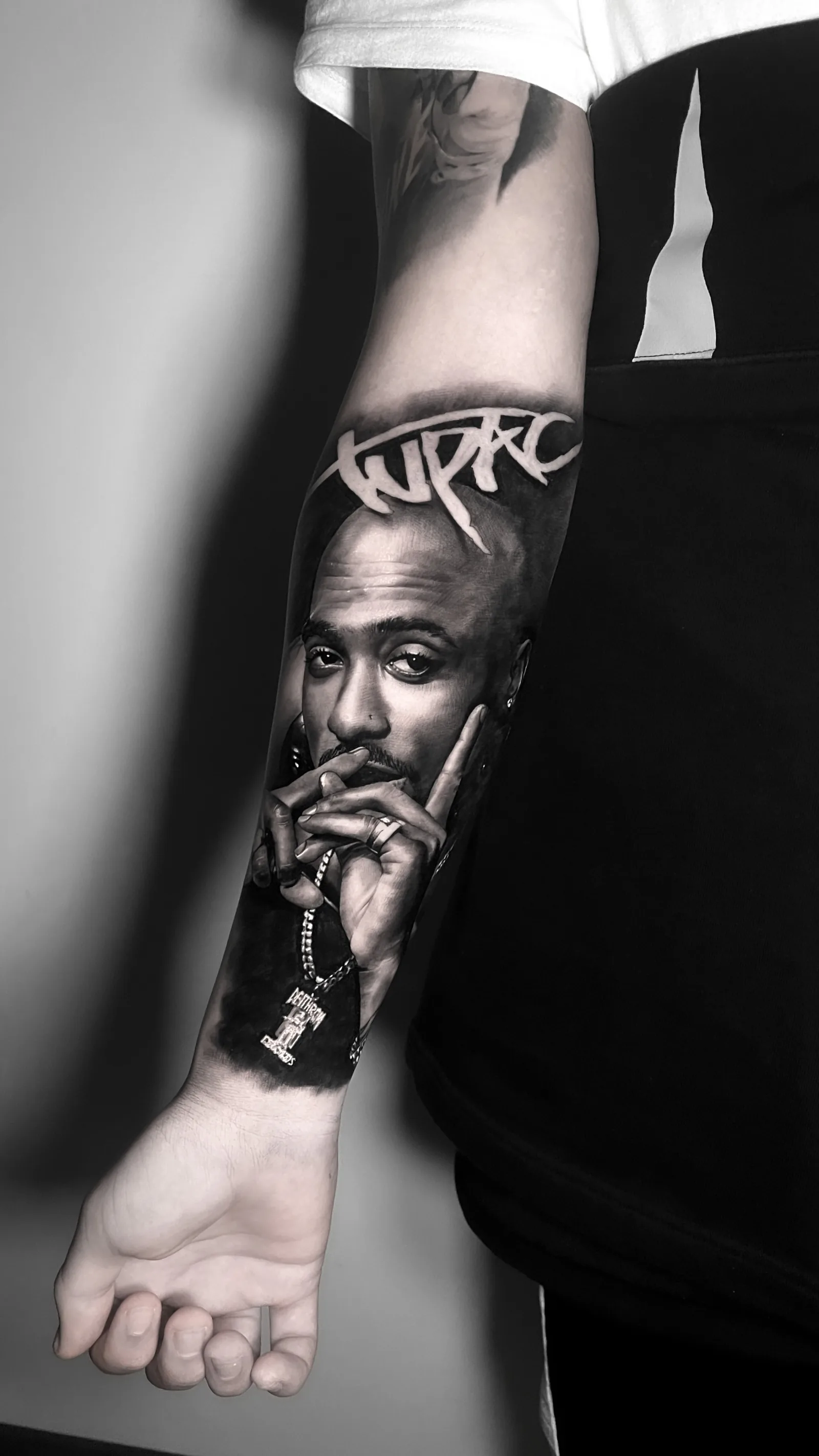 2Pac portrait – black & grey realism tattoo on the forearm by A-Dem